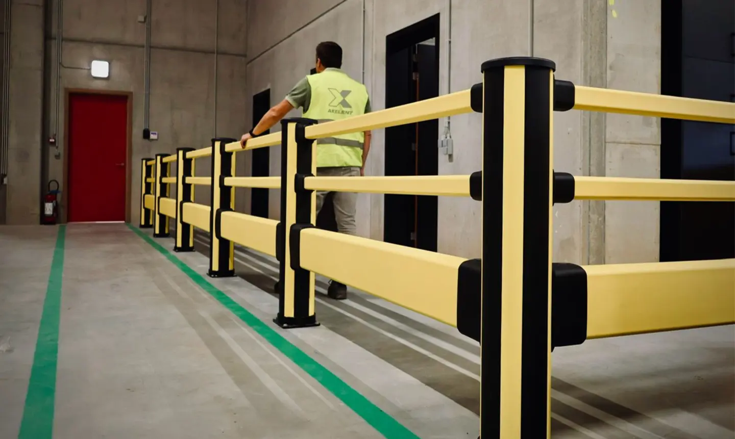 Pedestrian barrier is shown with a person wearing high visibility behind