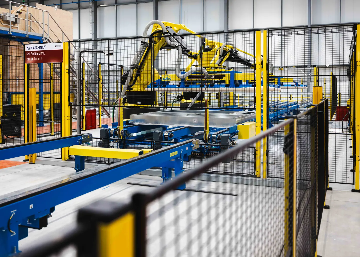 Machine mesh guarding fencing around a robotic arm and production line.