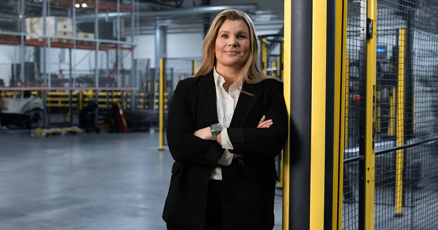 Axelent CEO Karin Sandén Ahlqvist stands cross armed lent against and Axelent safety bollard in the Axelent factory facility 