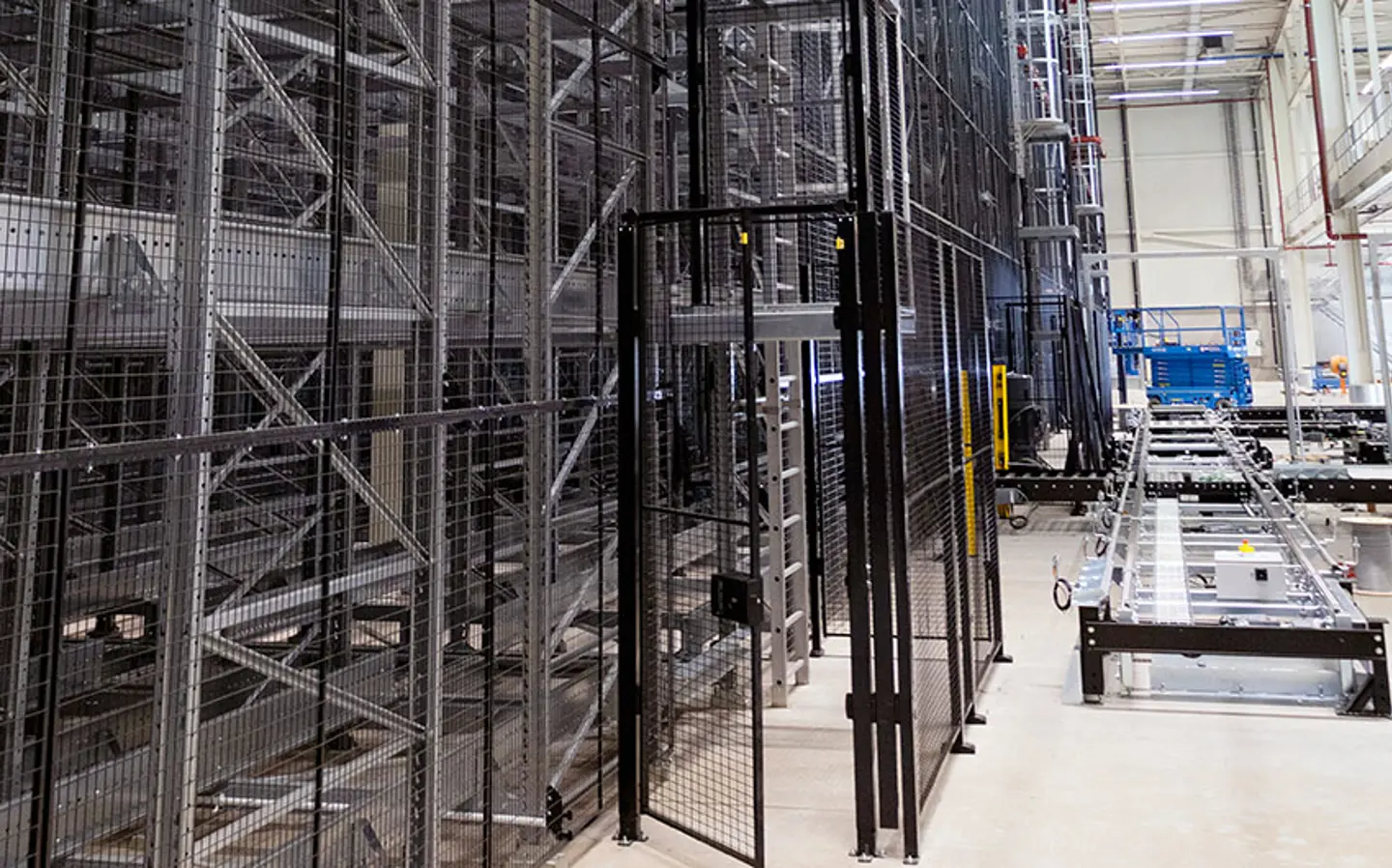 A warehouse automated storage system protected by machine guarding is shown with an open access door
