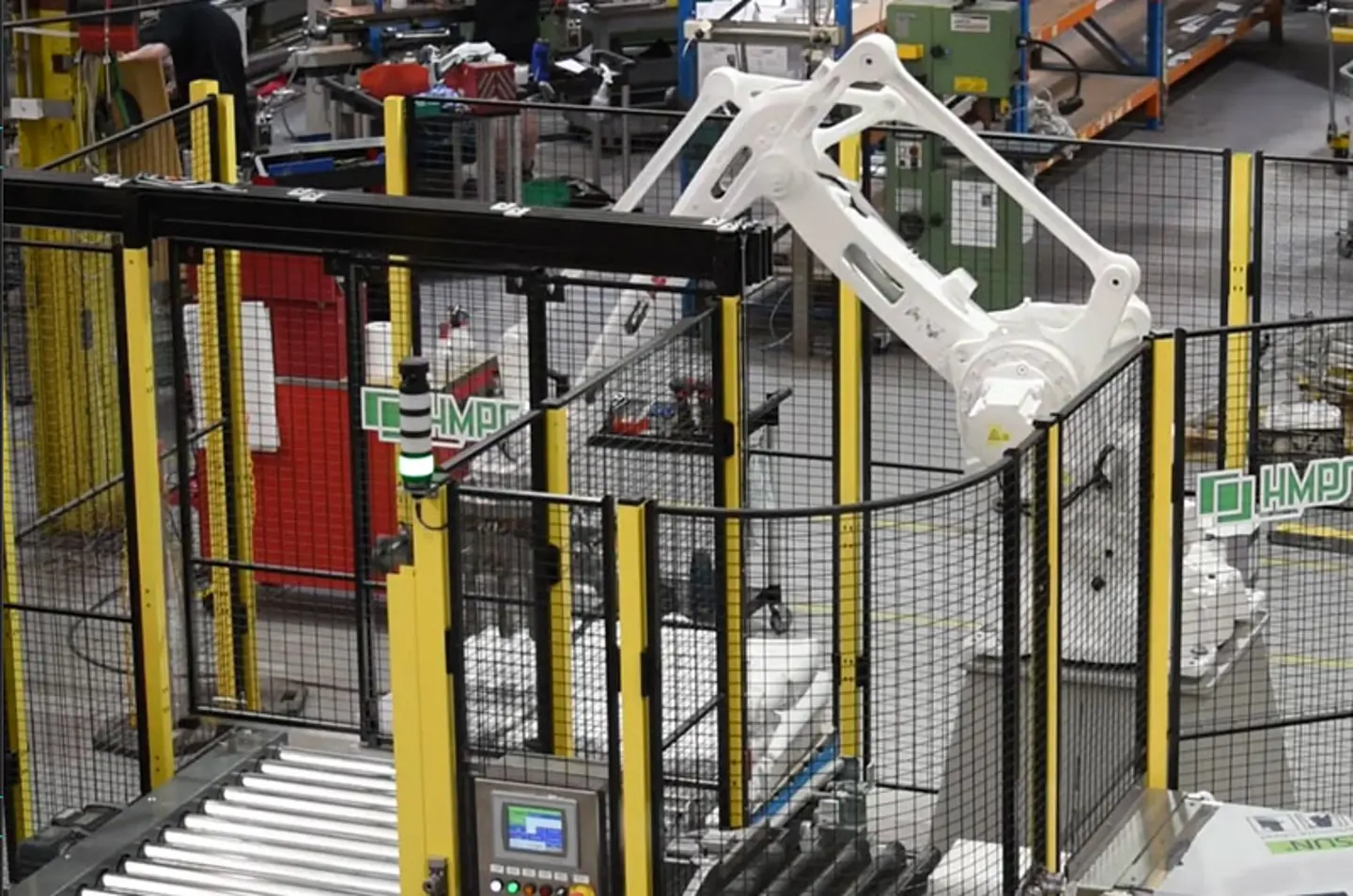 High-speed robotic palletizer stacking cases on pallets inside protected area