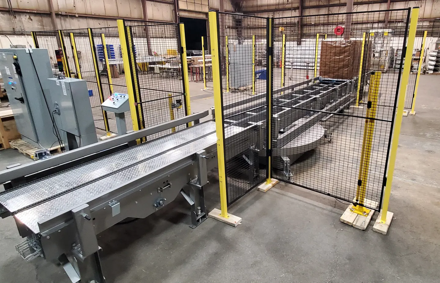 An automated palletiser and conveyor line surrounded by Axelent machine guarding