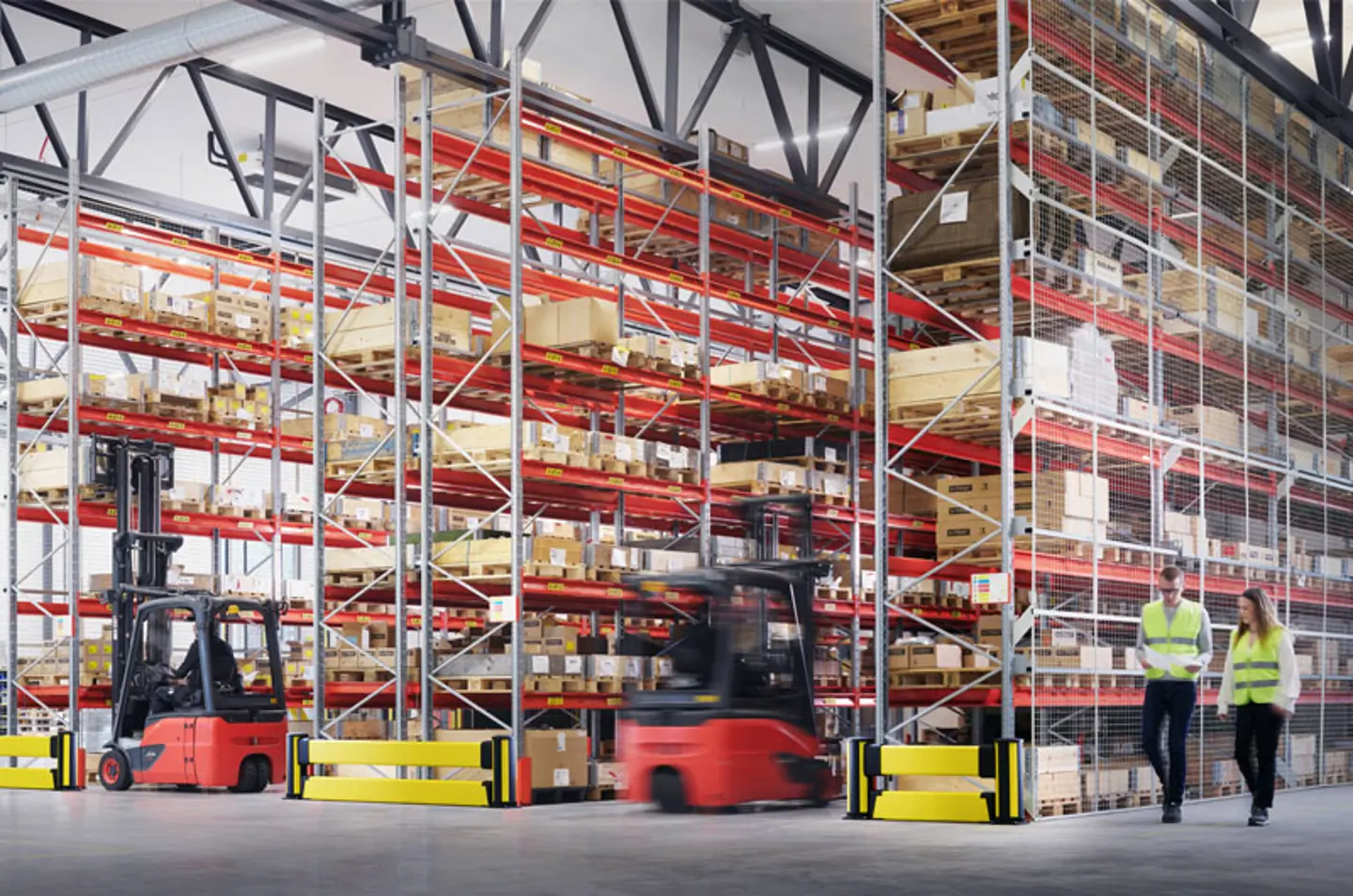 Warehouse racking shown with moving forklifts, people, and Axelent impact protection shown