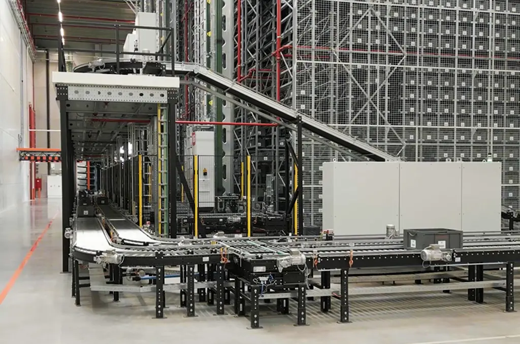 Automated roller and belt conveyor system in a warehouse, used for transporting totes and bins