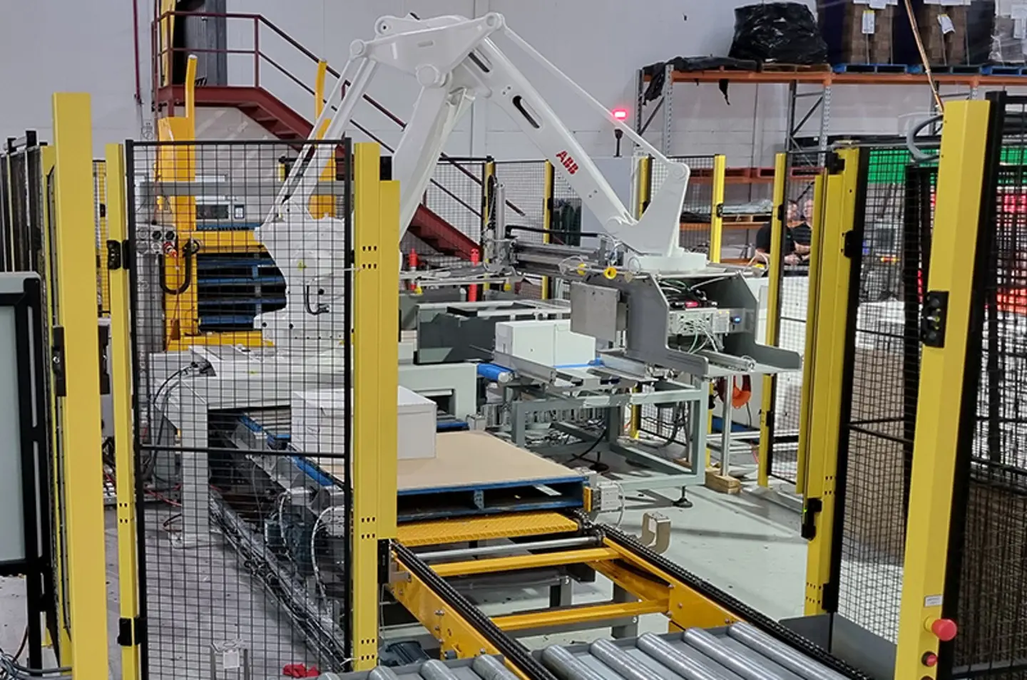 Robotic palletizer stacking large bags with machine guarding for operator safety